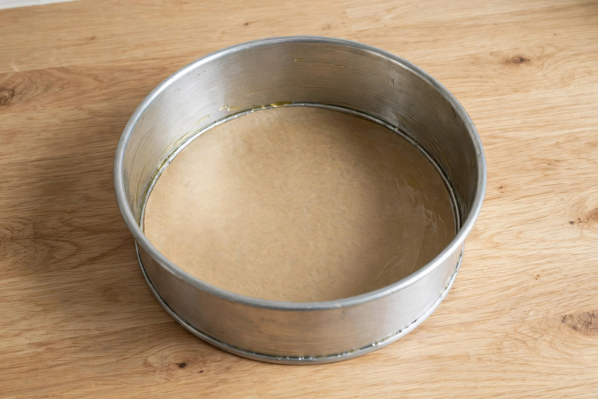 Greased 7-inch round aluminium cake mould lined with parchment paper